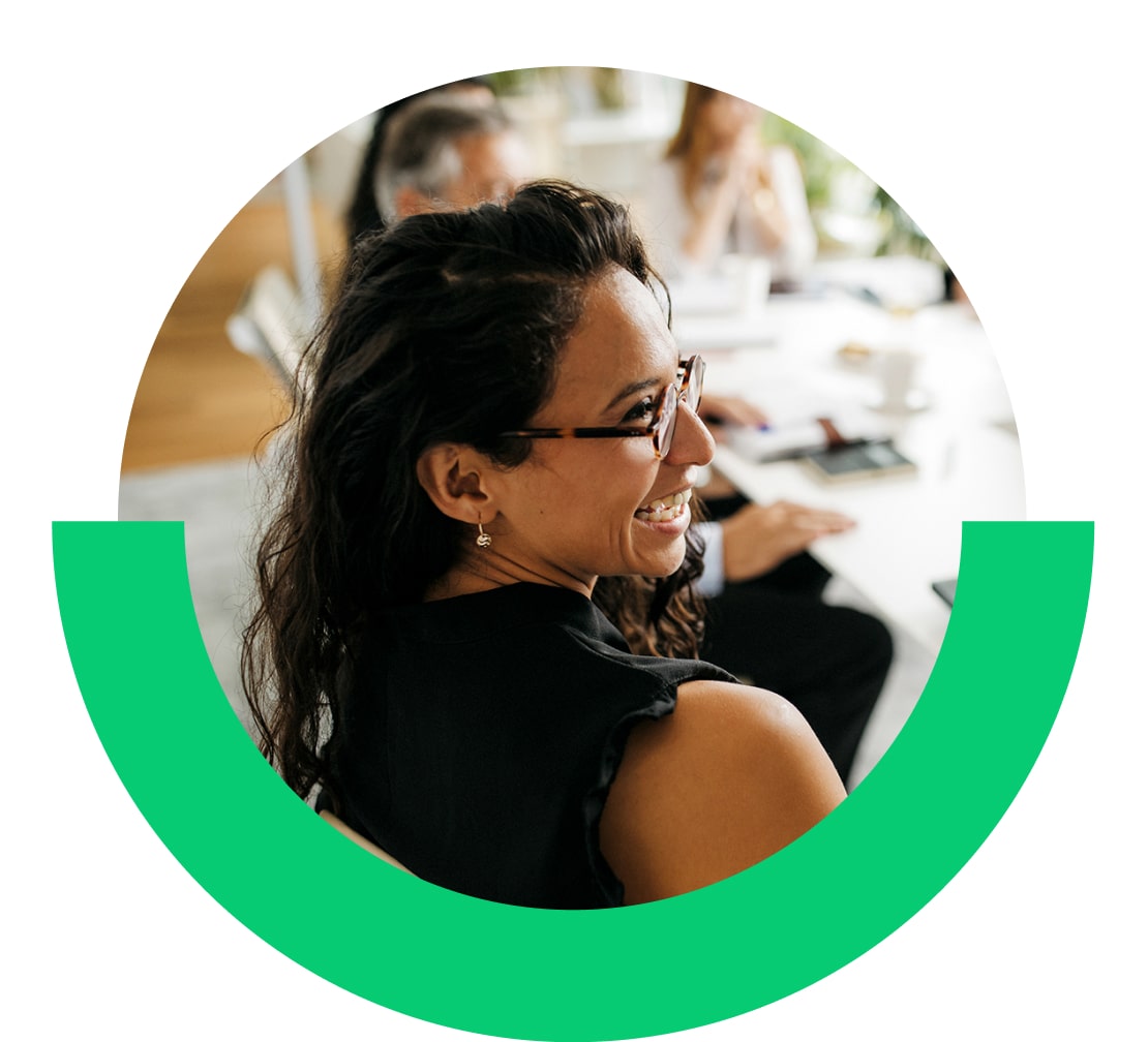 Vrouw in gesprek met collega’s in een kantoor.