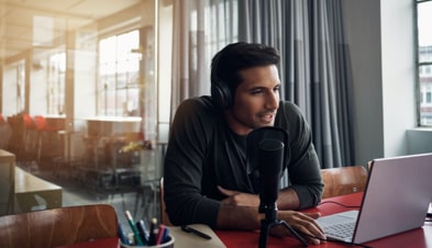 Man presenting on GoToWebinar with laptop and microphone 
