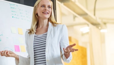 Woman giving presentation with whiteboard during meeting 