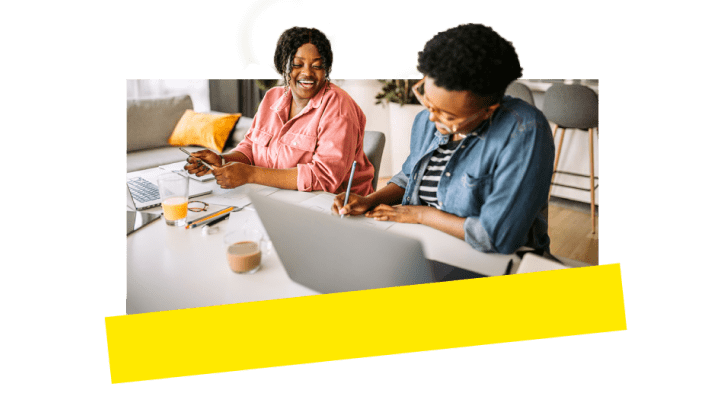 Duas colegas de trabalho rindo e se divertindo enquanto trabalham juntas usando ferramentas VoIP.